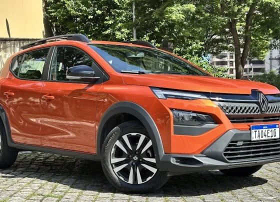 Renault Kardian Evolution MT laranja parado de frente com muro e árvore ao fundo