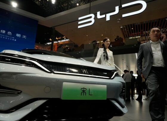 Uma modelo posa perto do carro elétrico BYD Song L durante a Auto China 2024, realizada em Pequim, em 25 de abril de 2024