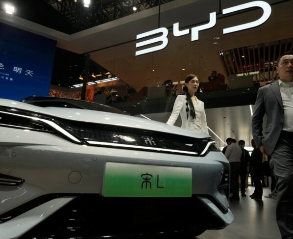 Uma modelo posa perto do carro elétrico BYD Song L durante a Auto China 2024, realizada em Pequim, em 25 de abril de 2024