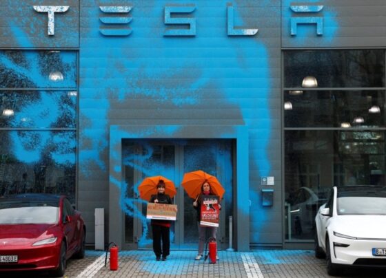 Apoiadores da Nova Geração (Neue Generation) protestam após pintarem com spray a fachada de uma concessionária Tesla para protestar contra Elon Musk e contra o que os organizadores dizem ser a destruição da democracia e do clima pelos ricos, em Berlim, Alemanha, em 31 de março de 2025