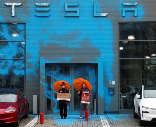 Apoiadores da Nova Geração (Neue Generation) protestam após pintarem com spray a fachada de uma concessionária Tesla para protestar contra Elon Musk e contra o que os organizadores dizem ser a destruição da democracia e do clima pelos ricos, em Berlim, Alemanha, em 31 de março de 2025